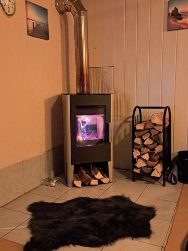 a room with a stove and a pile of logs at Apartment Schloffer in Weiz