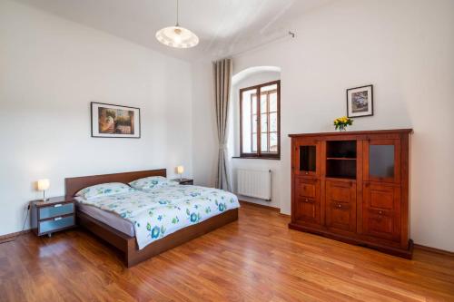 a bedroom with a bed and a wooden dresser at Starý farhof in Kutná Hora