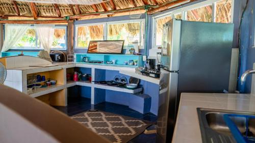 a kitchen with blue walls and a refrigerator at Agave-Blue in Bacalar