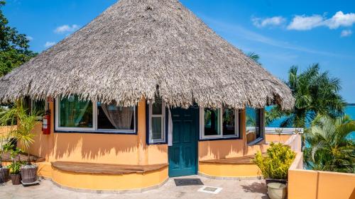 a hut with a thatched roof and a blue door at Agave-Blue in Bacalar