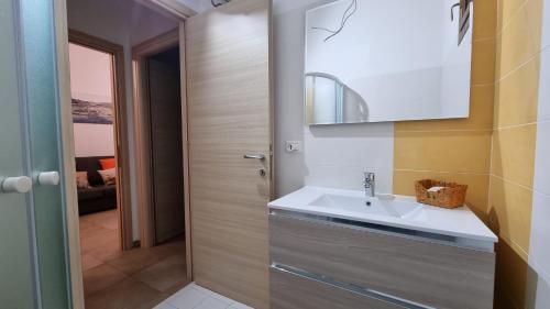 un baño con lavabo y espejo en Appartamento Tharros, en Cabras