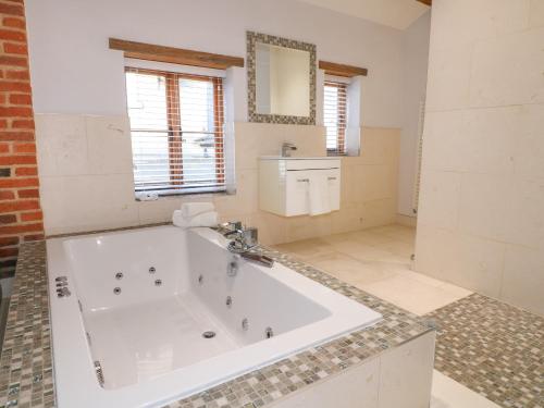 a large bathroom with a tub and a sink at The Old Dairy House in Ashbourne