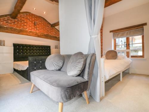 a bedroom with a couch and a bed and a window at The Old Dairy House in Ashbourne