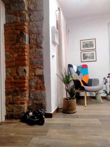 a living room with a chair and a brick wall at Borgo dei Centenari in Orgosolo