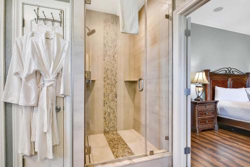 een douche met een glazen deur in een slaapkamer bij Livin' the Dream in Galveston