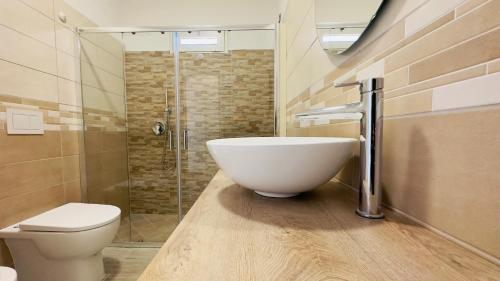 y baño con lavabo, aseo y ducha. en Ninfa sul Mare Apartments - A 50 Mt dal Mare, en Capo Vaticano