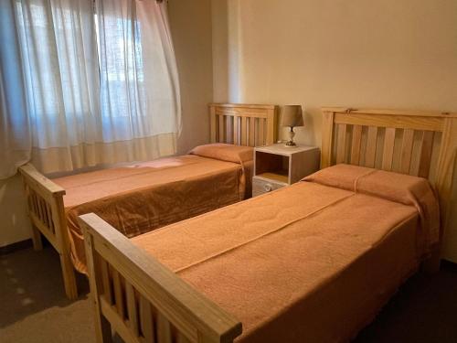 1 dormitorio con 2 camas y ventana en Departamento Borgoña en Salta