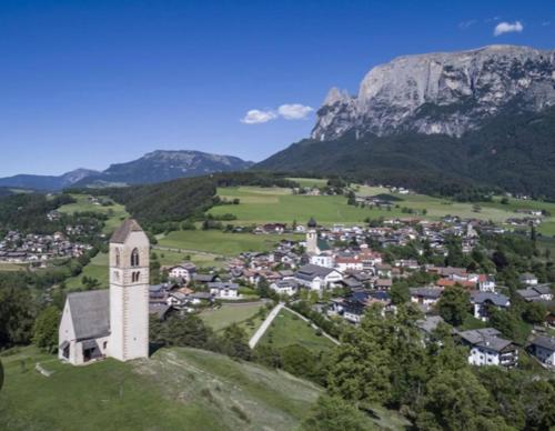 a small town with a church on top of a hill at Apartment Maximilian in Völs am Schlern