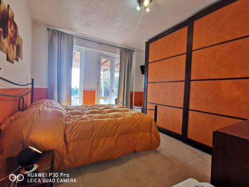 una camera da letto con un letto grande e una grande finestra di villa di charme con piscina e jacuzzi tra Roma e Viterbo a Fabrica di Roma