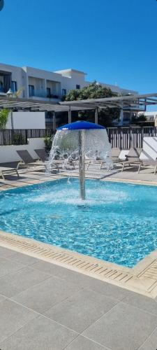 a fountain in the middle of a swimming pool at Cosmos Residence in Paralimni