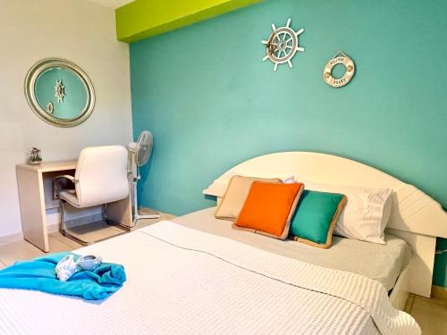 a bedroom with a bed with colorful pillows and a chair at Sermilie Beach Houses in Psakoudia