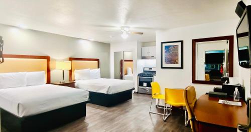Habitación de hotel con 2 camas y escritorio en Oceanside Inn & Suites, a Days Inn by Wyndham, en Fort Bragg