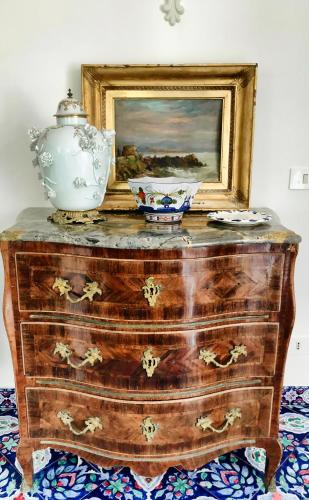 a dresser with a painting and a vase on top of it at Villa Silia in Capri