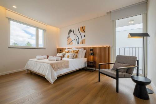 a bedroom with a bed and a chair and a window at Island Retreat Apt (city center) in Ponta Delgada