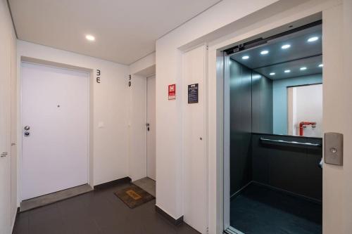 a hallway with a glass door in a building at Island Retreat Apt (city center) in Ponta Delgada