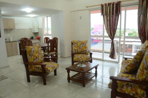 ein Wohnzimmer mit Stühlen, einem Tisch und Fenstern in der Unterkunft Apartamentos El Mirador in El Carmen
