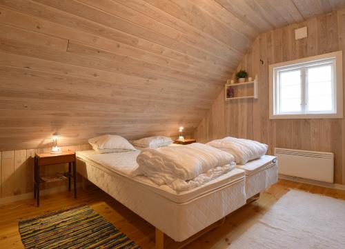 a bedroom with a large bed in a wooden wall at Genuine house on northern Gotland near Slite in Lärbro