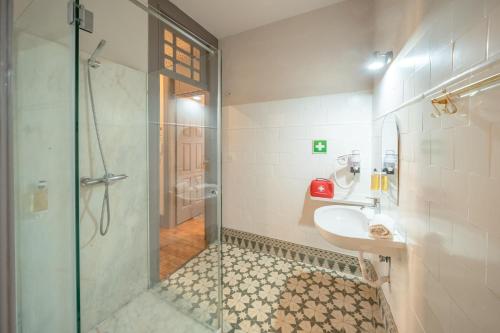 een badkamer met een glazen douche en een wastafel bij Feel Porto Antique Poveiros Flats in Porto
