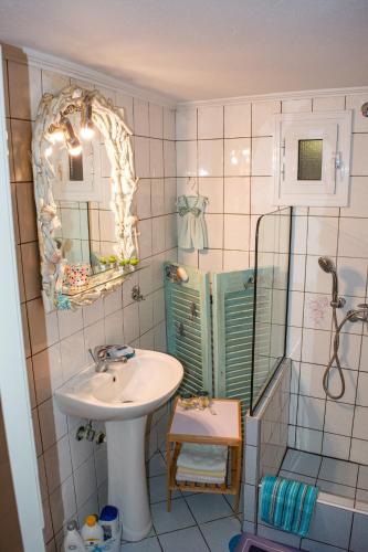 a bathroom with a sink and a shower with a mirror at Sofia's House in Paleo Tsifliki