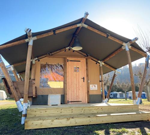 un pequeño edificio con una gran puerta de madera en un campo en Camping Gran Sol, en Montferrer