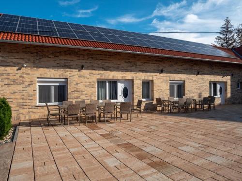 a building with chairs and solar panels on the roof at Andoravendégház - Villány in Villány