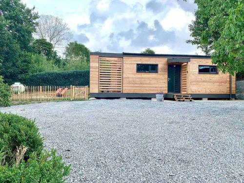 a small wooden house with a gravel yard at Le cabanon in Houffalize