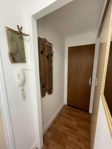 un couloir avec une porte et un téléphone sur un mur dans l'établissement Appartement T2, à Luchon