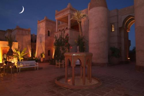 a courtyard of a building at night with a moon at La Maison Des Oliviers in Marrakesh