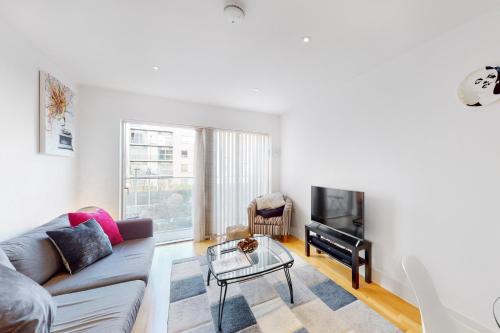 een woonkamer met een bank en een televisie bij Lovely 1 bed apartment in Streatham in Londen