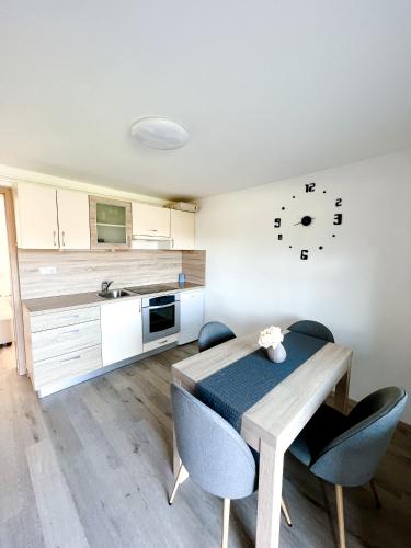 a kitchen with a table and chairs and a clock on the wall at Apartments Sole in Podčetrtek