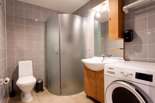 uma casa de banho com um frigorífico de aço inoxidável e um lavatório em ApartDirect Hammarby Sjöstad em Estocolmo