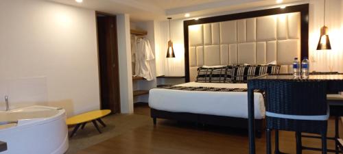 a bedroom with a bed and a sink and a tub at Hotel Bogota DC in Bogotá