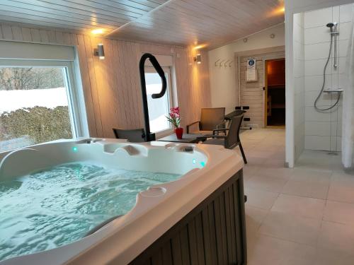 y baño grande con bañera grande. en Gîte 295 Montagnes du Jura avec Spa et Sauna classé 3 étoiles en Foncine-le-Haut