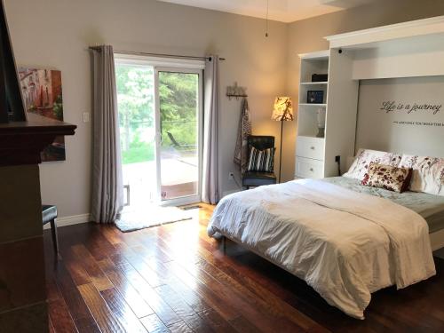a bedroom with a bed and a sliding glass door at Cozy Luxury on the Thames in Ontario! in London
