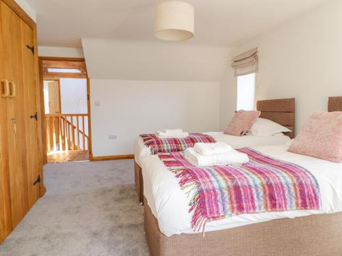a bedroom with two beds with towels on them at Cwmwr in Pen-y-bont-fawr