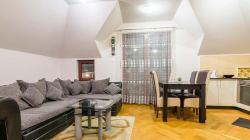 - un salon avec un canapé et une table dans l'établissement Apartman Adzic, à Zlatibor