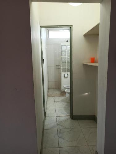 ein Bad mit einem WC, einem Fenster und einem Flur in der Unterkunft Casa Morales-Garcia in Campana