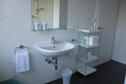 a white bathroom with a sink and a toilet at Apartment Velden - Angelika Berginz in Velden am Wörthersee