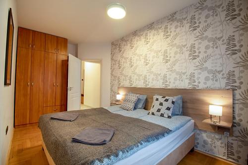 Postel nebo postele na pokoji v ubytování LOTUS Apartments GOZSDU