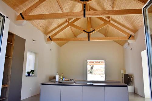 an open kitchen with wooden ceilings and a kitchen island at Monte Casa Branca in Montemor-o-Novo