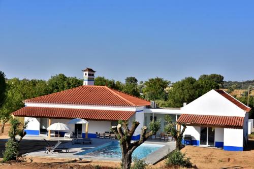 a villa with a swimming pool and a house at Monte Casa Branca in Montemor-o-Novo