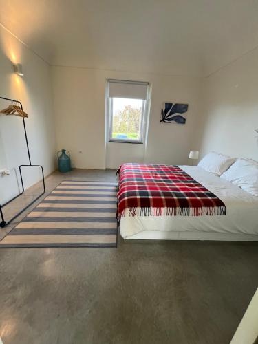 um quarto com uma cama com um cobertor xadrez em Monte Casa Branca em Montemor-o-Novo