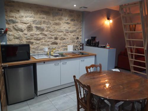 une cuisine avec une table en bois et une salle à manger dans l'établissement Studio à Theuville-Baigneaux, à Theuville