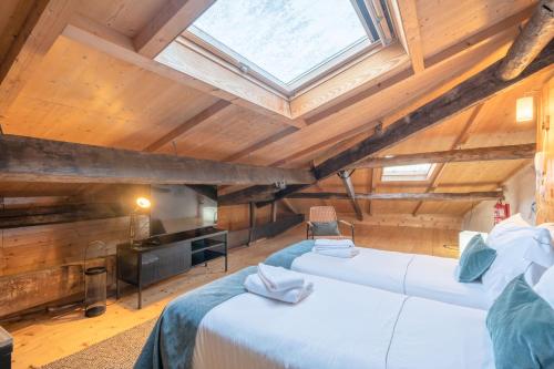 2 bedden in een zolderkamer met een dakraam bij Feel Porto Antique Poveiros Flats in Porto
