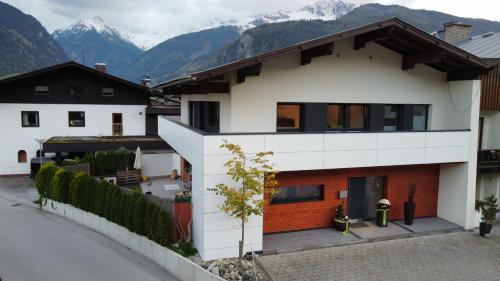 una casa blanca con montañas al fondo en Chalet Murmi, en Uttendorf
