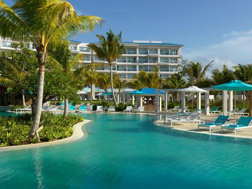 ein Pool mit Stühlen und ein Hotel in der Unterkunft Margaritaville Island Reserve Cap Cana Hammock - An Adults Only All-Inclusive Experience in Punta Cana