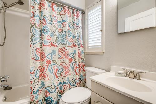 a bathroom with a toilet sink and a shower curtain at Exclusive Historical Townhome: serene and cozy in San Antonio