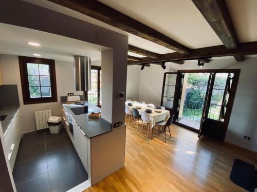 cocina y sala de estar con mesa y sillas en Casa Estrac, en Villanova