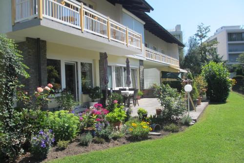a house with a bunch of flowers in the yard at Apartment Velden - Angelika Berginz in Velden am Wörthersee
