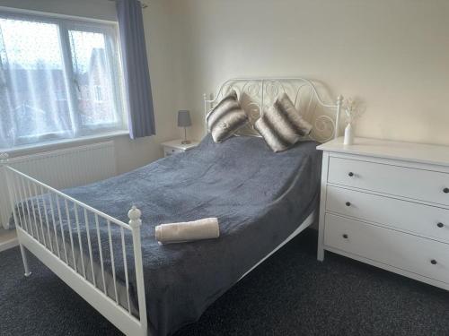 a bedroom with a white crib with pillows and a window at 3 Bedroom House For Corporate Stays in Kettering in Kettering